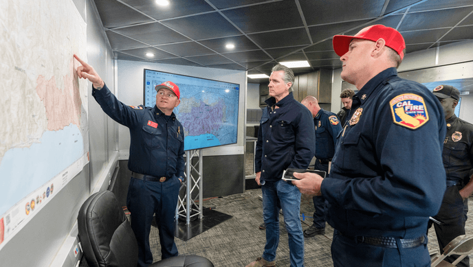 Governor Newsom and CalFIRE officers looking at a map