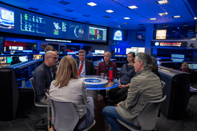 Governor Newsom at a table with JPL staff in the control room